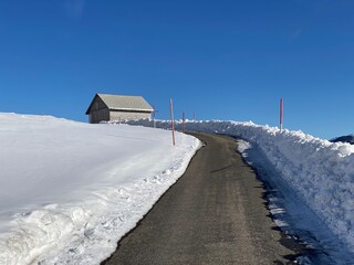 Obraz premium Winter snow idyll along the rural alpine road above the Obertoggenburg valley and on the slopes of the Alpstein mountain range - Alt St. Johann, Switzerland (Schweiz)