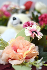 Bouquet of flowers and Teddy Bear background blur