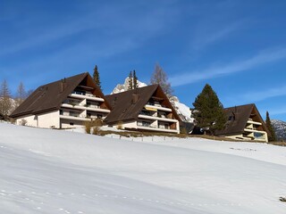 Traditional Swiss architecture and wooden alpine houses in the winter ambience of fresh white snow cover, Alt St. Johann - Obertoggenburg, Switzerland (Schweiz)