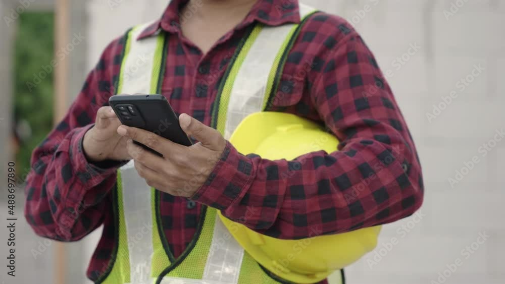 Poster asian architect engineer worker man in protective helmet and uniform using smart phone mobile app wi