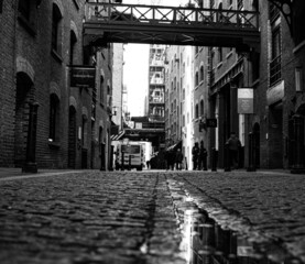 A ground level grayscale shot of Shad Thames street, London