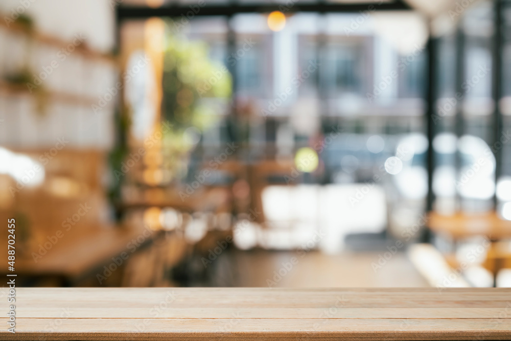 Poster empty wooden table in front of blurred background of coffee shop. copy space for display or montage 