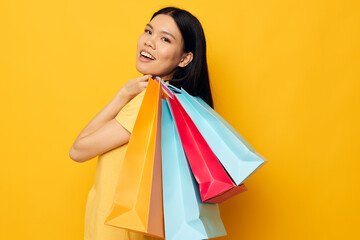 Portrait Asian beautiful young woman with packages in hands shopping studio model unaltered
