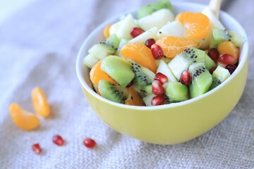 fruit salad of tangerines kiwi apples pomegranate seeds. healthy eating