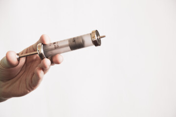 replaceable old glass syringe in the doctor's hands, injections