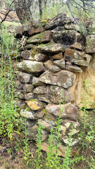 Fototapeta na wymiar Rough dry stone rock retaining wall overgrown with moss and lichen Newnes New South Wales Australia