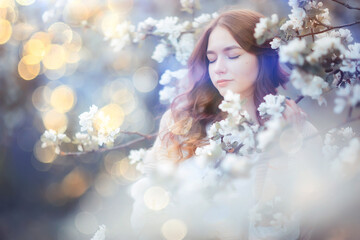 spring portrait of an adult happy woman in a blooming garden, sun rays and glare, april flowers girl