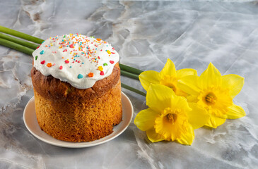 Easter cake and daffodil flowers on kitchen table.