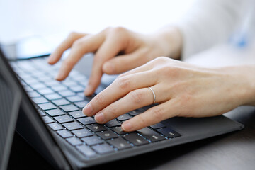 ノートパソコンでタイピングをするアジア人の女性の手元	