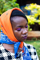 Portrait of a young African women in a headscarf - obrazy, fototapety, plakaty