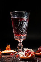Antique crystal glass with pomegranate juice on a dark background