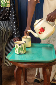 Young African woman pouring a cup of tea 