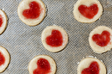 Shortbread cookie dough with raspberry jam on baking sheet. Selective Focus.