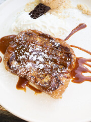 chocolate and caramel crepe pancake with icing sugar on a plate in restaurant in brittany france