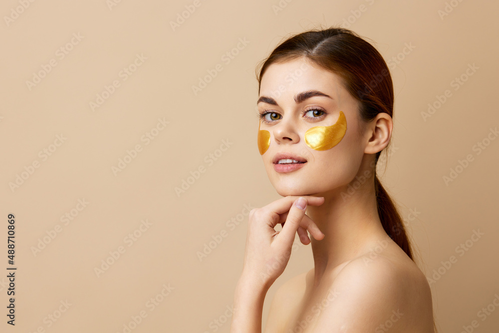 Wall mural young woman patches rejuvenation skin care fun after shower beige background