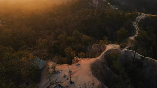 Beautiful winding mountain trails among the green nature of Pai Canyon during a sunset in Mae Hong Son in Thailand. Top down drone panning shot