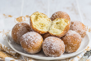 Fried curd balls with sugar on white wooden background. Concept of coffee break. Copy space.