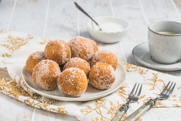 Fried curd balls with sugar on white wooden background. Concept of coffee break. Copy space.