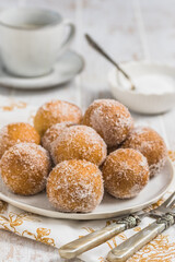 Fried curd balls with sugar on white wooden background. Concept of coffee break. Copy space.