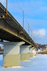 close-up, part of road bridge across the river Tom, Siberia. Ice, cold February, winter. selective focus