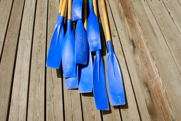 Blades of plastic paddles for canoes on the background of a wooden deck, the concept of rowing.Copy...