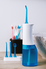 Blue home oral irrigator kit in bathroom, Waterpik for teeth cleaning, portable water flosser for...