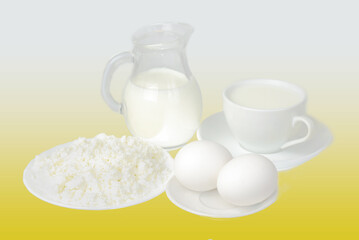 Milk in a jug, milk in a cup, eggs and cottage cheese on a saucer