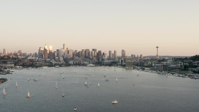 Wide aerial shot pulling away from the Seattle skyline with sailboats floating on the water.