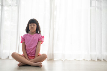Fototapeta na wymiar Asian girl meditating, lovely kid