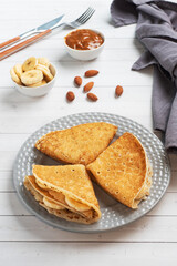 Pancakes with chocolate banana filling. Concept delicious breakfast, a white wooden table.