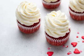 Red velvet cupcakes with cream cheese frosting on light background. Valentine's Day concept. Selective focus.