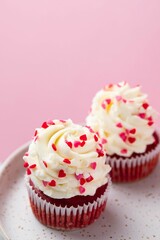 Red velvet cupcake with cream cheese frosting and red hearts sprinkles on the top. Valentine's Day concept. Selective focus.