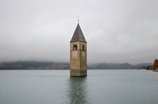The Steeple of the old Church in the submerged Village of Curon, rising above the surface of Lake Reschen (in Curon Venosta, Italy) 