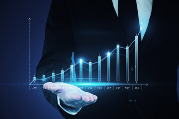 Close up of businessman hand holding abstract glowing business chart hologram. Annual report, economy and technology concept. Double exposure.