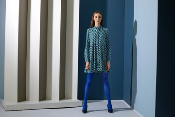High fashion portrait of young elegant woman in retro fashion outfit. Blue dress, blue tights,