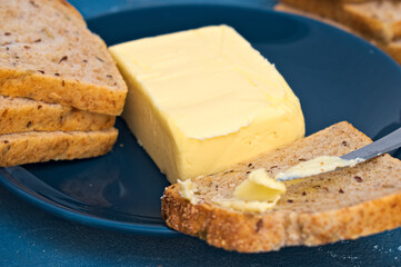 butter and toast bread on a blue plate. close. macro.