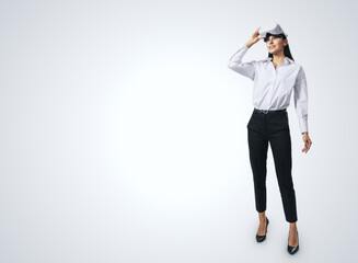 Virtual reality concept with stands at full length young woman looking up and VR headset on her head on abstract light grey background with place for your logo or text, mockup