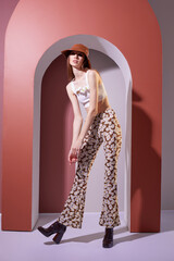High fashion spring portrait of young elegant woman in retro outfit. Retro pants, panama hat,...