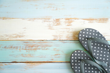 Closeup top view studio shot four pairs travel colorful summertime fashionable rubber flip flops slipper shoes placed on light blue old retro vintage wooden pattern table background with copy space