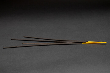 Black aromatic incense sticks on a black background