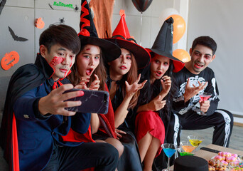 Group of Asian young scary creepy male and female friends in Halloween witch sorcerer ghost and...
