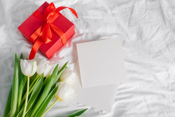 Tulips flowers, red gift box and empty card for text. Mock-up. Concept of womans day, mothers day