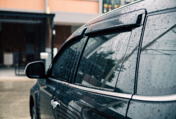 Water droplets on car windshield. Heavy rain fell on the roof of the car. Driving on rainy days, be...