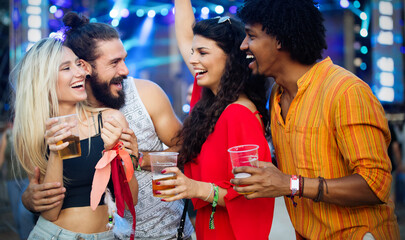 Cheerful happy group of friends partying in club at night
