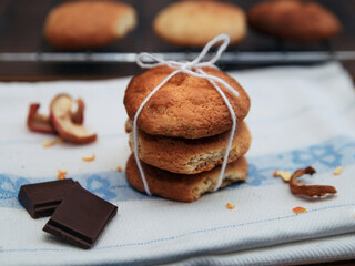 Three cupcakes and pieces of chocolate on white towel