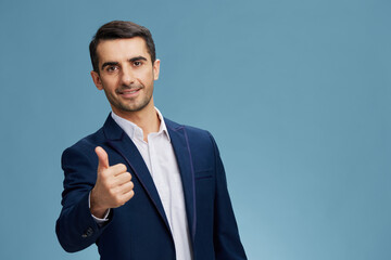 boss in a blue suit thumb up gesticulates with hands blue background