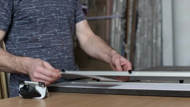 Framing Workshop cutting cardboard carton frame. Making baguette handmade picture frame at studio.