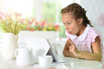 Portrait of  Beautiful little girl with tablet pc has an idea