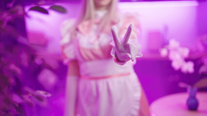 Headless pink maid cosplay show piece sign gesture with fingers in kitchen - obrazy, fototapety, plakaty