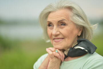 happy  senior woman  posing by the lake